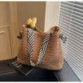 Detalle de bolso tote de paja tejido a mano con asas de pañuelo a rayas y anillas metálicas - Caqui