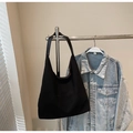 Detalle del bolso hobo de pana negra con textura de canalé y correa de cuero al hombro - Negro