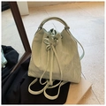Detalle del bolso tipo saco verde menta con textura plisada y cordón con lazo frontal - Verde