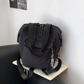 Mochila ligera de nailon negro con colgante de oso plateado en un sofá negro - Negro Con Colgante