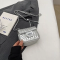 Chic silver crossbody bag with V-quilted texture and metal chain strap on grey blazer - Silver Small