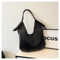 Detail of minimalist black tote bag with unique knot shoulder strap and sleek vertical seams - Black
