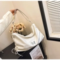 White hobo shoulder bag with metal butterfly logo and adjustable strap in a lifestyle setting - Off-white