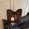 Dunkelbraune Tote Bag mit Schaf-Plüschanhänger auf Ledersofa in urbanem Stil - Mit Anhänger / Kaffeebraun