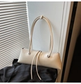 Detail of cream glossy patent leather baguette bag with long tassels and silver rivets - White