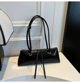 Detail view of a black glossy patent leather baguette bag with long zipper pulls - Black