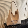 Beige canvas tote bag with brown leather handles and blue graphic print on sofa - Khaki