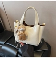 Detail of creamy white leather bucket bag with embossed logo and cute bear charm - With Pendant / White