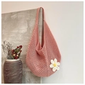 Detalle de bolso tote tejido naranja con una flor de ganchillo 3D en la pared - Rosa