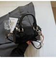 Detalle del bolso Boston de terciopelo negro con herrajes dorados y accesorio - Negro Con Colgante