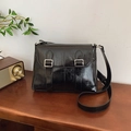 Glossy black faux leather crossbody satchel bag with silver metal buckles and shoulder strap - Black