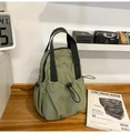 Detail view of army green outdoor backpack with drawstring pockets on a rustic wooden table - Army Green
