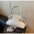 Close-up of a light blue leather shell bag with round handles and silver hardware detail - Blue