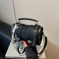Schwarze Zylindertasche aus Leder mit Hasenprägung und dekorativen Silberanhängern - Schwarz