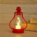 Detail of a vintage red LED lantern with warm candle light on a white table background - Red