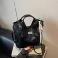 Schwarze gesteppte Eimertasche mit Silberbeschlägen und rosa geflochtenem Anhänger - Mit Anhänger / Schwarz