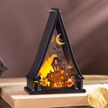 Macro shot of Halloween decorative lantern with castle and bat prints and warm LED glow - Castle