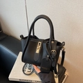 Chic black lychee grain leather bucket bag with gold clasp and elegant top handles - Black with Pendant