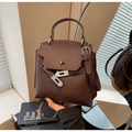 Vue détaillée du sac trapèze en cuir grainé marron foncé avec fermoir en métal argenté - café
