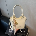 Bolso tipo cubo en cuero charol beige crema con acabado brillante y correa ajustable - Con Colgante / Blanco Roto