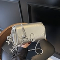 Silberne Umhängetasche aus Metallic-Leder mit Ballonhund-Anhänger und Drehverschluss - Mit Anhänger / Silber