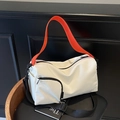 White canvas Boston bag with vibrant orange straps and black adjustable crossbody strap - White