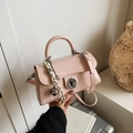 Pink glossy leather crossbody bag with round lock and woven bell charm accessory - With Charm / Pink