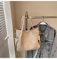 Detailansicht einer beigen Canvas-Tragetasche mit MIDOLAI-Aufdruck und praktischer Seitentasche - Khaki