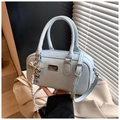 Elegante borsa Boston azzurra con manici e un ciondolo a fiocco argentato - Blu con ciondolo