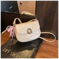Detail of cream patent leather saddle bag with silver buckle and pearl bow charm - With Charm / White