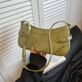 Sac baguette vert olive avec rivets argentés et boucles réglables tenu à la main - Vert