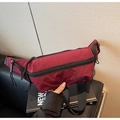 Détail du sac bandoulière bordeaux en nylon avec tissu texturé et fermetures éclair - Rouge