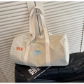 Dettaglio borsa da viaggio in tela beige con ricamo WE arancione e toppa smiley blu - Bianco Sporco
