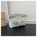 Detailed view of butterfly print makeup bag with gold outlines and zipper on wooden desk - Blue Butterfly Pattern (Style 2)