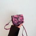 Rosa und schwarze Mini-Satteltasche in Schlangenoptik mit silberner Schnalle - Rosarot