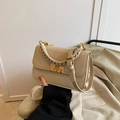 Chic beige crossbody bag with woven handle and gold buckle, paired with elegant coat - Apricot