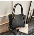 Close-up of black lychee grain leather bucket bag with gold hardware and bear charm - Black With Pendant