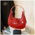 Détail du sac hobo rouge avec relief crocodile, fermetures argentées et fini brillant - Rouge