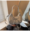 Détail du sac croissant argenté avec texture givrée, nœud et fermeture zippée - Argenté