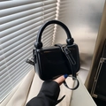 Minimalistische schwarze glänzende Handtasche mit Rundgriff und verstellbarem Riemen - Schwarz