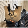 Detalle del bolso tote caqui con colgante de felpa, logotipo y textura mate suave - Caqui con Colgante