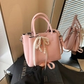 Pink leather bucket bag with elegant pearl chain and silk bow on black art book - With Charm / Pink