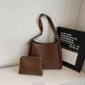 Detail van de donkerbruine lederen shopper tas en bijpassende pouch set op witte basis - koffiekleur