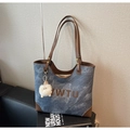 Detalle del bolso tote de textura denim con asas de cuero marrón y bordado VWTU - Azul con Colgante