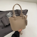 Borsa a secchiello beige con trama litchi e manico annodato su blazer grigio - Albicocca Senza Pendente