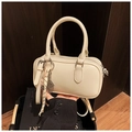 Detail of cream white leather boston bag with tennis racket charm and hand-held view - White with Pendant