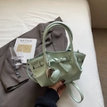 Mint green bucket bag with heart pendant and adjustable strap on a gray suit - Green with Pendant