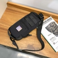 Tactical black nylon chest bag with iridescent logo and MOLLE system on wooden surface - Black