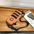 Tactical crossbody bag in orange brown with MOLLE system on wooden table for outdoor use - Orange