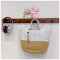 Dettaglio della borsa tote intrecciata con ciondolo a nappa e perla di legno su gancio - Bianco